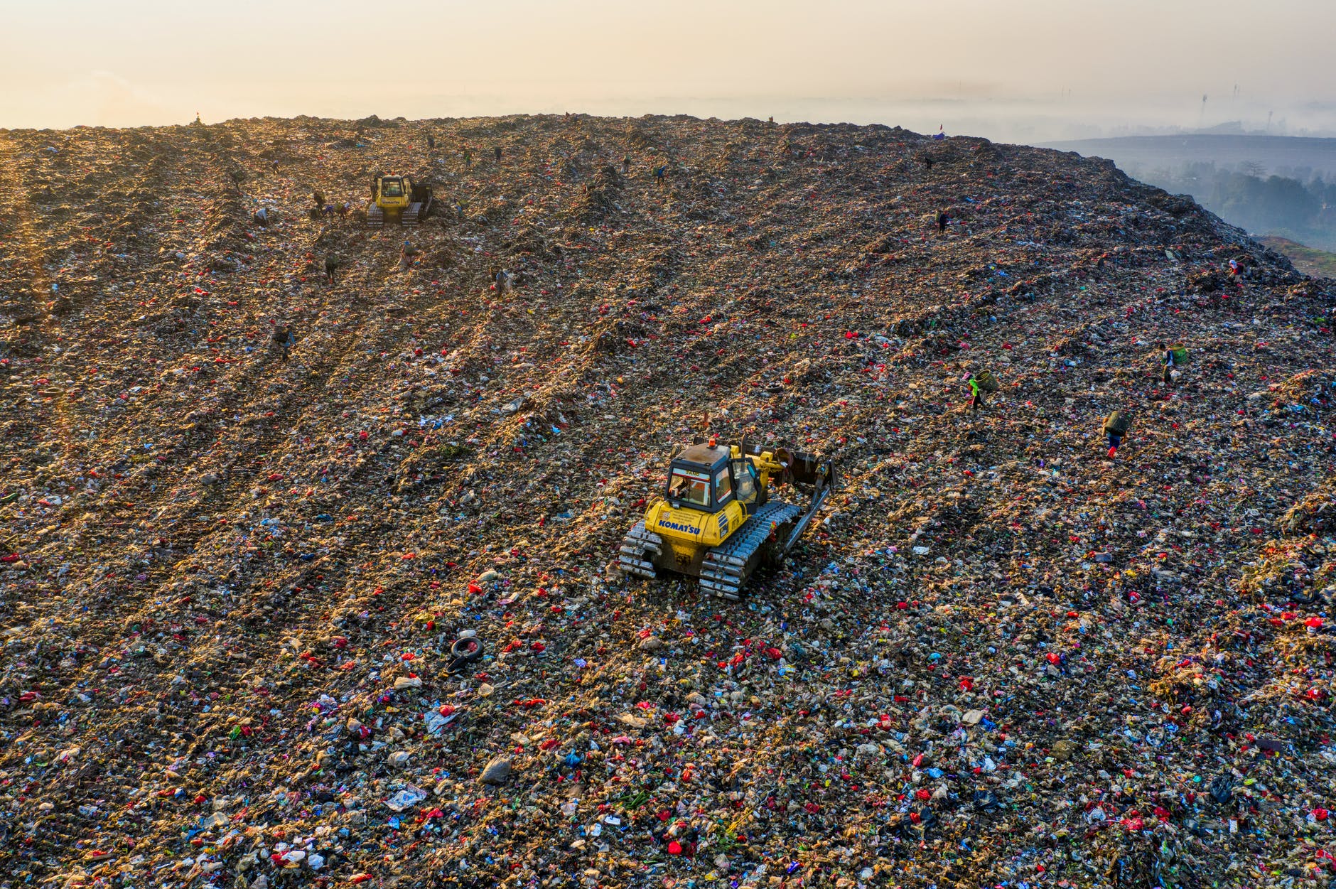 yellow heavy equipment on landfill